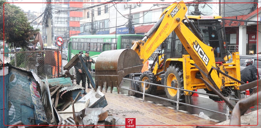   काठमाडौँ महानगरपालिकाले थापाथलीमा बनेका अस्थायी संरचनामा डोजर चलायो (तस्बिरहरू)
