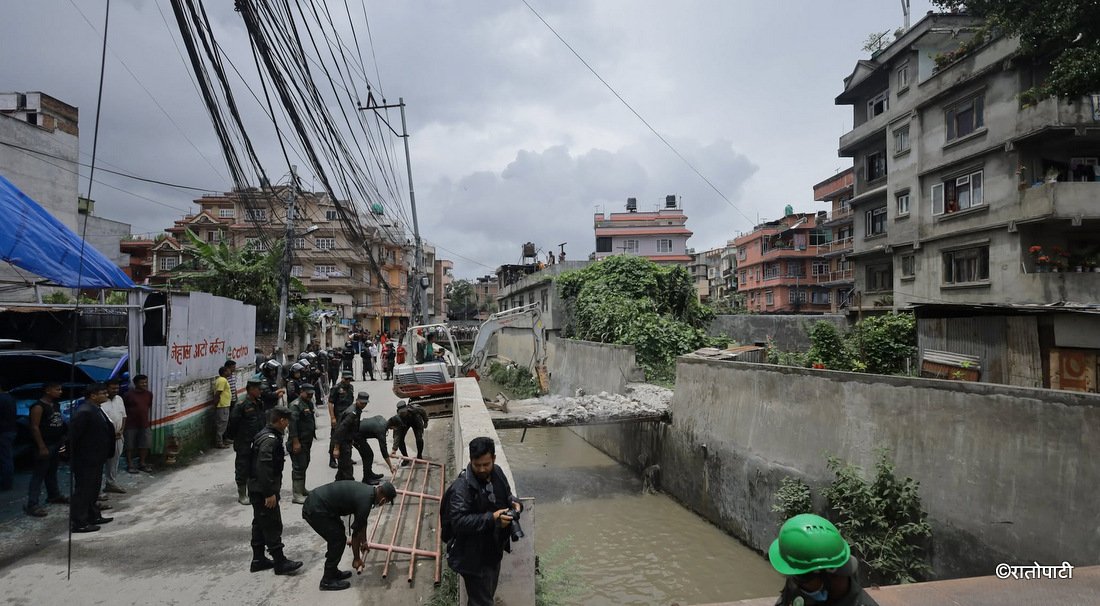   मनमती खोलामाथि बनेका स्वीकृति बेगरका संरचनामा महानगरको डोजर (तस्बिरहरू)
