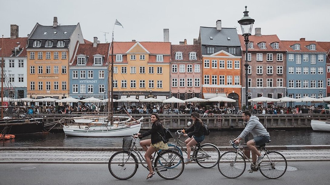 On-Copenhagens-latest-bridge-three-cyclists-share-a-vibrant-pathway-beneath-a-clear-white-and
